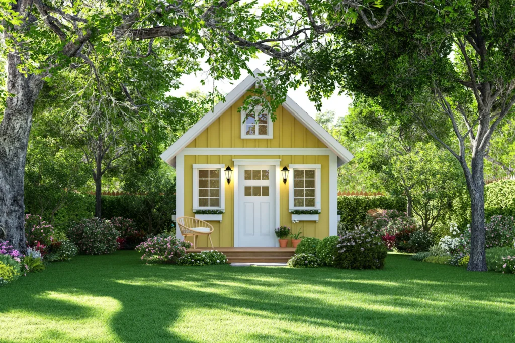 Yellow cottage surrounded by lush green garden.