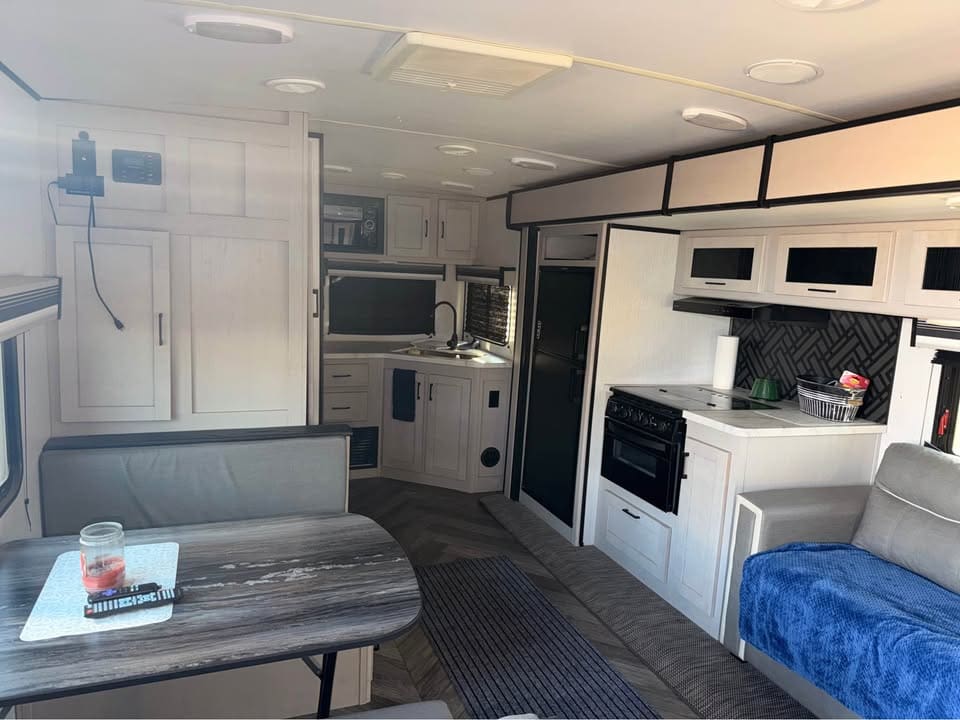Modern RV interior with kitchen and seating.
