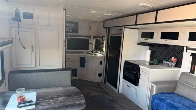 Modern RV interior with kitchen and dining area.