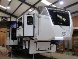 White RV trailer inside a large garage.
