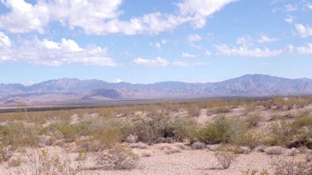 Desert landscape with mountains and cloudy sky.